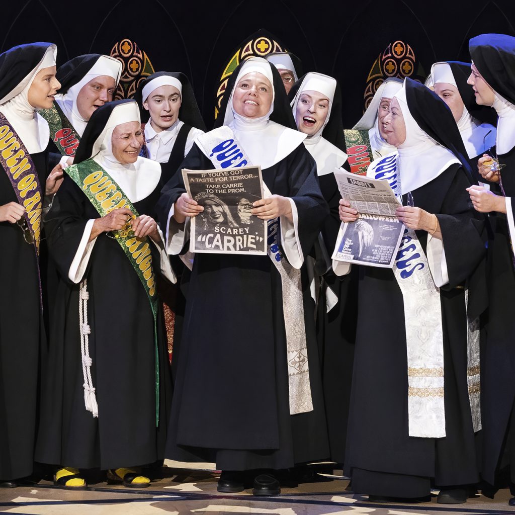 Billede fra 'Sister Act' på Det Ny Teater med en scene, der fremviser Nonnerne i deres farverige kostumer og optræden